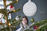 sasha hiding behind the christmas tree