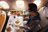 a man sitting in the emirates first class suite