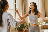 Asian woman looking frustrated arguing with her mom in the living room.