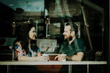 Photo of a man and a woman talking at a table