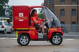 Picture of someone driving a very small royal mail car