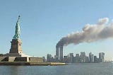 Statue of Liberty in foreground, smoking World Trade Center in background on 9/11/01