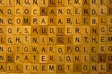 picture of Scrabble tiles next to one another with some words spelled including comparable, shuddering and toward