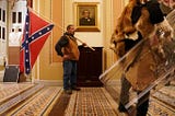 An insurrectionist carries a Confederate flag through the U.S. Capitol, January 6th 2021.