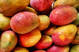 A pile of red and yellow mango fruit.