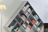 A white pyramid shape slanting bookshelf