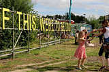 Children and adults dancing by sign saying ‘If this were to be lost’ by community garden in Peterborough