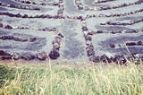 A labyrinth made of stones and sand, surrounded by grass