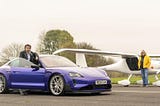 "Richard Hammond está de pie junto a un Porsche Taycan azul con matrícula RE24 ZJK, mientras James May está de pie junto a una avioneta eléctrica blanca con matrícula G-KOKO. Ambos están en una pista de aterrizaje.