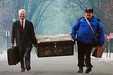 Neal and Del carry a trunk