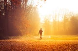 Man walking through clearing in the woods alone.