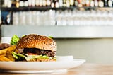 A burger and french-fries on a plate.