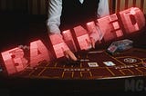 Banned from casinos — Dealer at casino with the word Banned written across the table