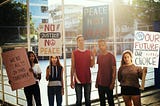 Group of teenagers protesting demonstration holding posters antiwar justice peace concept