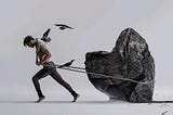 A man alone pulling a stone and move forward to achieve his goal