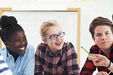 a teacher telling something to four student all sitting around a table