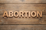 The word “Abortion” on wood