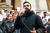 Zohran Mamdani (black coat, front, holding microphone) addresses a crowd at the Resist Fascism rally in Bryant Park on October 27, 2024.