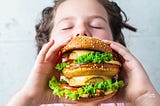 Person about tobite into an enormous hamburger
