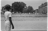 “Little Rock, 1959. Mob marching from capitol to Central High,” 1959. Photograph shows a young African American boy watching a group of people, some carrying American flags, march past to protest the admission of the “Little Rock Nine” to Central High School. Courtesy Library of Congress, Prints and Photographs Division. Photo: John T. Bledsoe