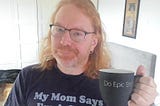 Chris Heilmann wearing a T-Shirt saying “My Mom says I’m a catch” and holding a cup saying “Do Epic Shit”