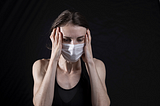 Woman wearing facemask, looking anxious