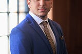 Professional headshot of the author wearing a suit and tie.
