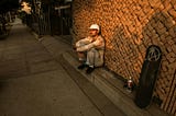 homeless man sitting in alley