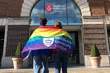 Students with an LGBT+ pride flag outside Middlesex University