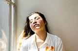 A woman resting her head against the wall