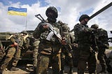 Infantry gather for an operation, 4 soldiers stand with a Ukrainian flag in the backround. They have forest camo and AK 47s.