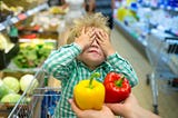 Boy in shopping cart with hands over his eyes, about to choose between a yellow pepper and a red pepper, gratitude, law of attraction, Tim’s Gratitude Experiment