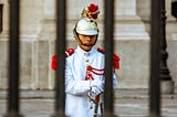 Guard behind bars of a historical building.