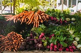 A bounty of fresh vegetables piled on a table at a farmer’s market