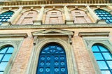 Entrance to Munich’s Altes Pinakothek Art Museum — a red stone facade and huge green door