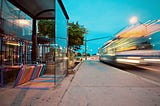 A bus stop with a bus passing it.