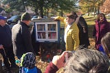 Little library book cabinet at Judson and Lindell, surrounded by community members