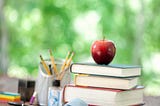 A stack of books with an apple on top