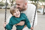 father with son on a swing