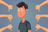 A man feeling sad at receiving several thumbs down as a sign of rejection