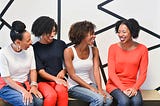 Group of natural hair black women laughing and talking