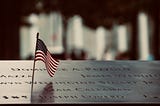 an american flag waving over an engraved plaque