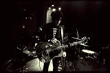 Jesse Malin in concert holding a guitar