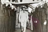 Naval officer being saluted by sailors