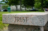 A stone bench with Trust engraved on it