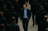 A lone individual walks against the flow of a large crowd, symbolizing courage, individuality, and the strength to stand out.