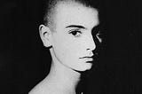 Black and white portrait of Sinéad O'Connor circa 1987. Close up of her face turned 3 quarters towards