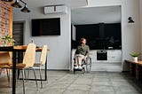A woman in a wheelchair alone in her house