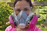 picture of author in a P-100 respirator and clear eye glasses in her yard