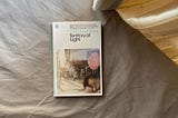 A book entitled Territory of Light written by Yuko Tsushima flatlays on a sheet bed